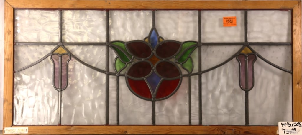 FRENCH ART NOUVEAU STAINED GLASS PANEL: French Art Nouveau stained glass panel with floral medallion and symmetrical amber and purple floral motif accent Approximate dimensions: h. 22.5", w. 44.5" Disclaimer: This is an online court ordered