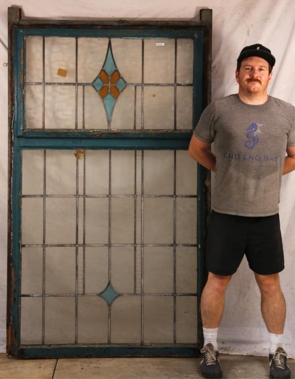 ANTIQUE CONTINENTAL STAINED GLASS PANEL: Antique Continental stained glass panel with blue and yellow rhombic medallion and colorless leaded glass panels. Approximate dimensions: h. 75", w. 44" Disclaimer: This is an online court ordered ban