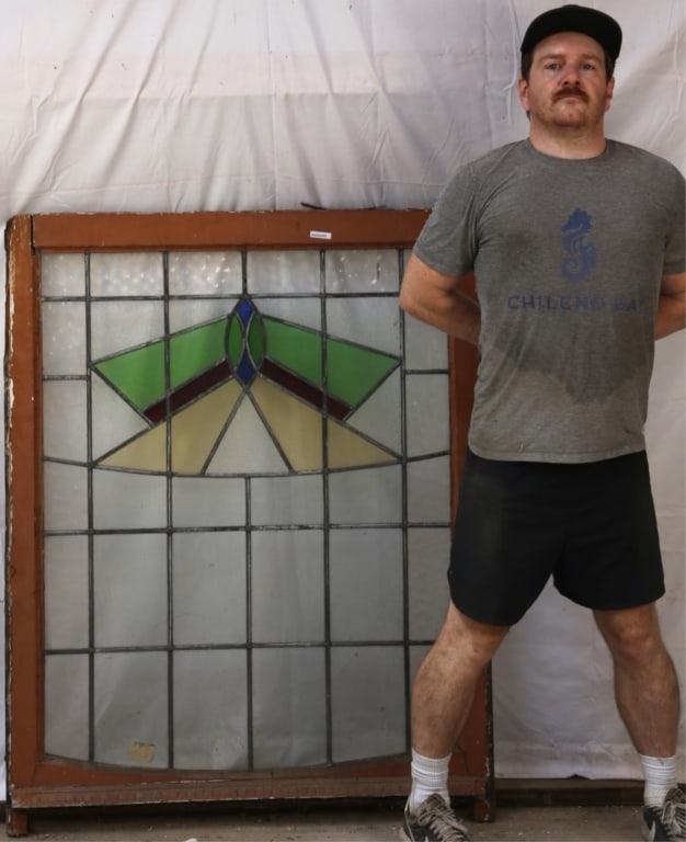 IRISH ART DECO STAINED GLASS PANEL: Irish Art Deco stained glass panel with a multicolored geometric medallion. Approximate dimensions: h. 51.5", w. 40" Disclaimer: This is an online court ordered bankruptcy sale. Participating bidders