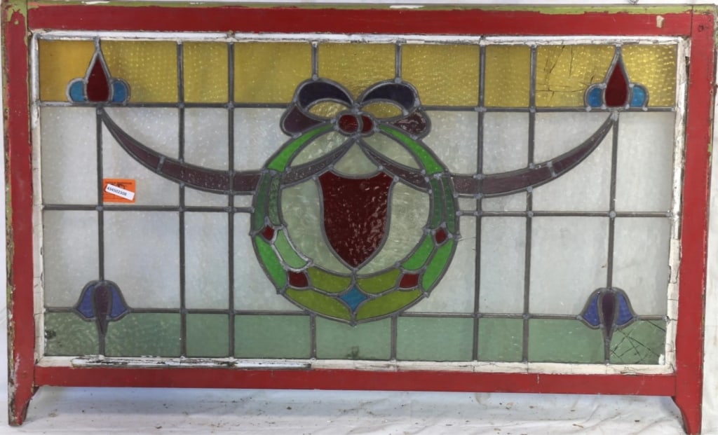 ENGLISH STAINED GLASS PANEL: English stained glass panel with a wreath medallion and garland motif with floral multicolored accents. Approximate dimensions: h. 27.5", w. 43.5" Disclaimer: This is an online court ordered bankruptc