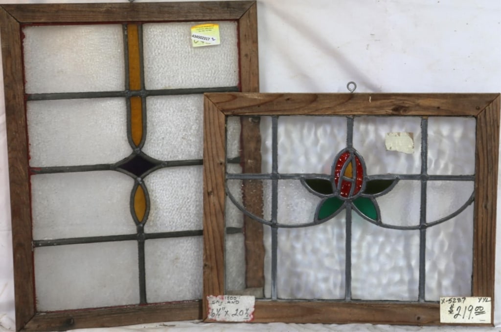 TWO ENGLISH STAINED GLASS PANELS: Two English stained glass panels, one with a floral medallion and the other with a blue and amber abstract medallion. Approximate dimensions: h. 16.5", w. 20" Disclaimer: This is an online court order