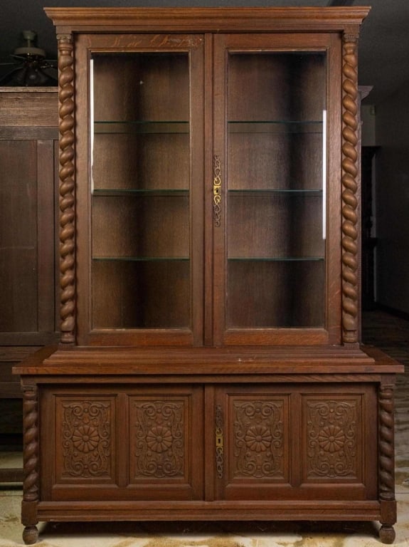 ENLGISH CARVED OAK VITRINE CABINET: English carved oak vitrine cabinet, with carved barley twist column decorations and floral carved rosettes. Approximate dimensions: h. 68", w. 49", d. 17.75" Disclaimer: This is an online court ordere