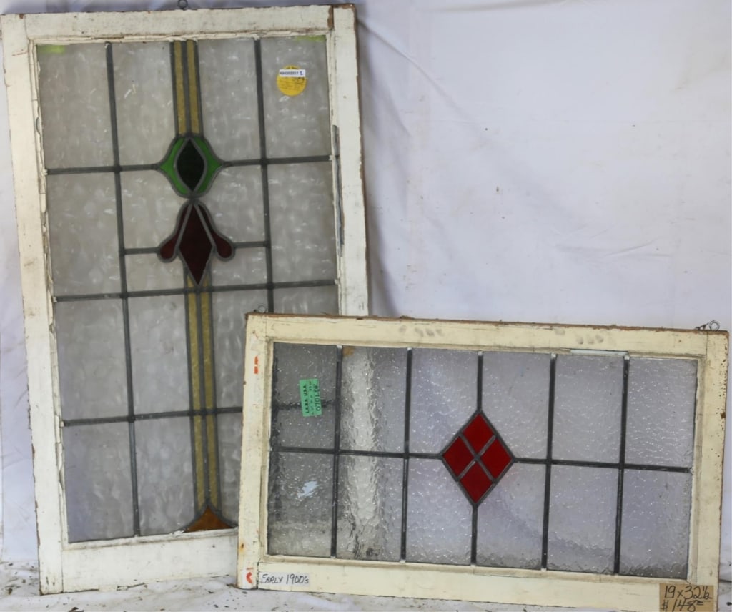 TWO CONTINENTAL STAINED GLASS PANELS: Two Continental stained glass panels, one with a rhombic red stained glass medallion, and the other with an abstract multicolored floral motif medallion. Approximate dimensions: h. 19", w. 32.5" Discl