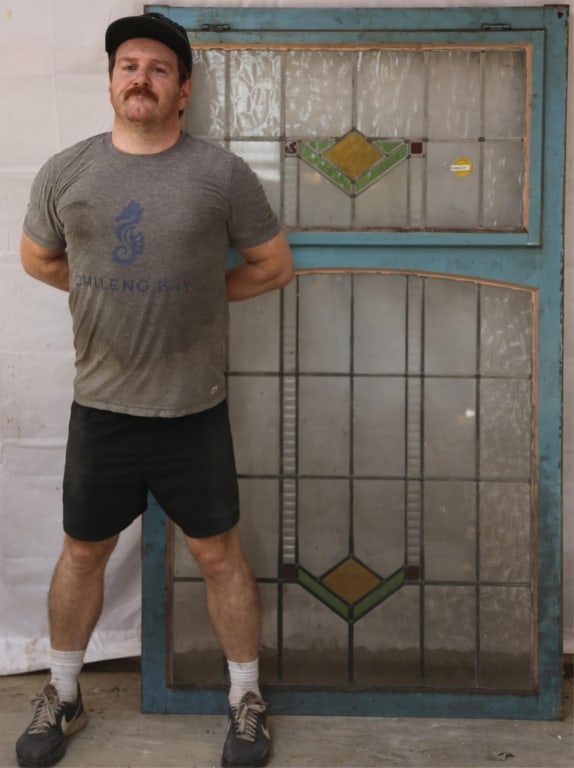 ENGLISH ART DECO STAINED GLASS PANEL: English Art Deco stained glass panel with geometric green, yellow, and red medallions, colorless leaded glass panels, some textured. Approximate dimensions: h. 68", w. 40" Disclaimer: This is an onlin