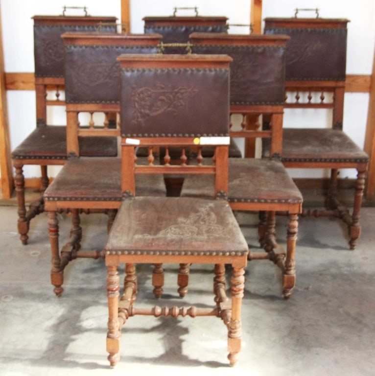 SET OF 6 HENRY ll STYLE DINING CHAIRS: Set of six Henry II style dining chairs with embossed leather backs, carved spindles, nailhead trim accents, brass pulls, turned legs, and stretcher bases. Approximate dimensions: h. 39", w. 17.5", d.