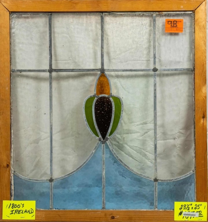 ANTIQUE IRISH STAINED GLASS PANEL: Antique Irish stained glass panel with amber, green, purple, and blue stained glass accents. Approximate dimensions: h. 23.5", w. 25" Disclaimer: This is an online court ordered bankruptcy sale. Parti
