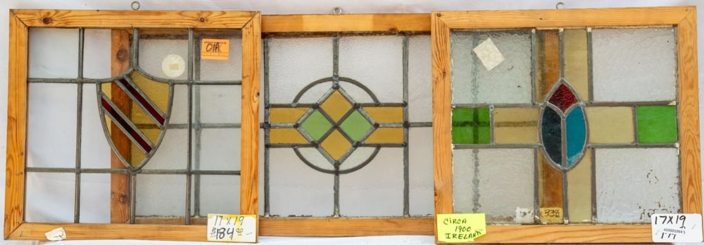 THREE FRENCH STAINED GLASS PANELS: Three French stained glass panels: one with a central shield-shaped stained glass medallions, and two with geometric medallions. Approximate dimensions: h. 16.5", w. 32.5" Disclaimer: This is an onlin