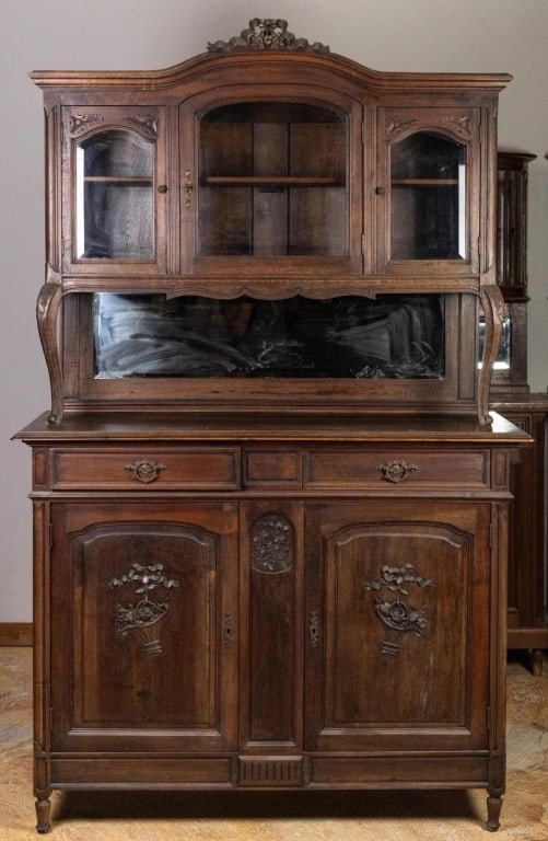 FRENCH ART NOUVEAU VITRINE BUFFET: French, Art Nouveau vitrine buffet with beveled glass cabinet, mirrored backsplash, ribbon and bouquet carvings, inset panels, cabriole vitrine supports, and floral-carved crest. Approximate dimension