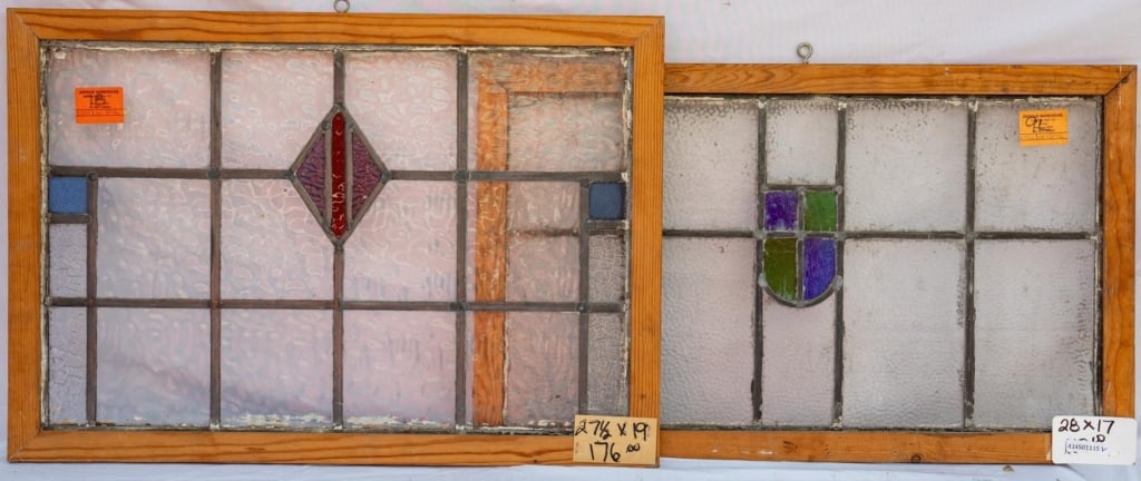 TWO FRENCH STAINED GLASS PANELS: Two French stained glass panels, one with a central shield medallion and the other with a central rhombic detail and blue square accents to the sides. Approximate dimensions: h. 19", w. 27.5" Disclaim