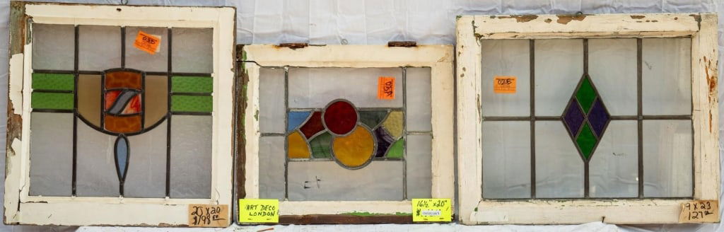 THREE FRENCH STAINED GLASS PANELS: Three French stained glass panels with textured, opalescent stained glass accents and abstract central details. Approximate dimensions: h. 19", w. 23" Disclaimer: This is an online court ordered bankr