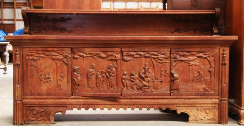BELGIAN RENAISSANCE REVIVAL SIDEBOARD: Belgian Renaissance Revival sideboard with a carved apron and wood appliqués, adorned with intricately carved genre scenes on the cabinet doors. Approximate dimensions: h. 49", w. 91.5", d. 24.5" Dis