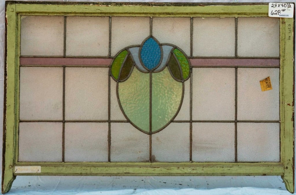 FRENCH ART NOUVEAU STAINED GLASS PANEL: French Art Nouveau stained glass panel with a central floral medallion and blue textured stained glass accent. Approximate dimensions: h. 24", w. 40.5" Disclaimer: This is an online court ordered bank