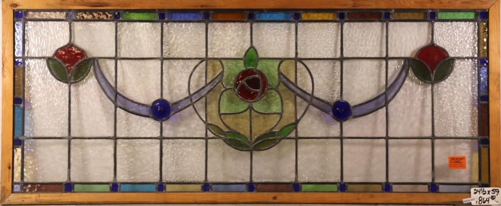 FRENCH ART NOUVEAU JEWELED STAINED GLASS PANEL: French Art Nouveau jeweled stained glass panel with central floral medallion, two symmetrical floral details to the sides, two blue jeweled elements, and blue ribbon detail. Approximate dimensions: h.