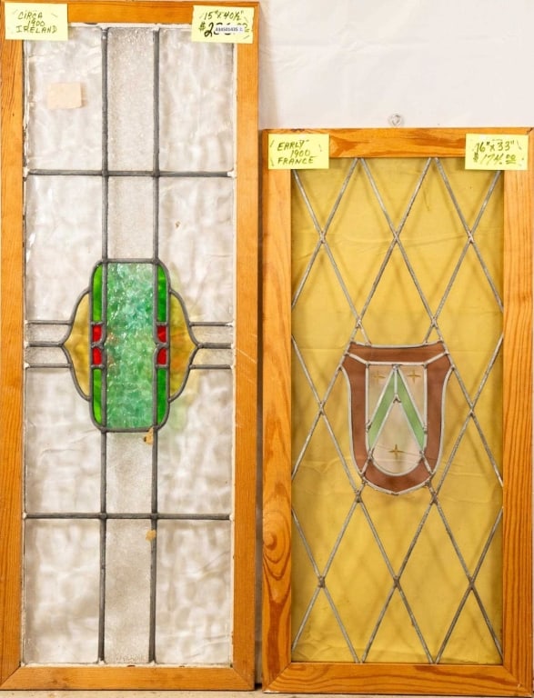 TWO CONTINENTAL STAINED GLASS PANELS: Two Continental stained glass panels, one with a shield-shaped medallion and the other abstract with textured stained glass accents. Approximate dimensions: h. 40.5", w. 15" Disclaimer: This is an onl