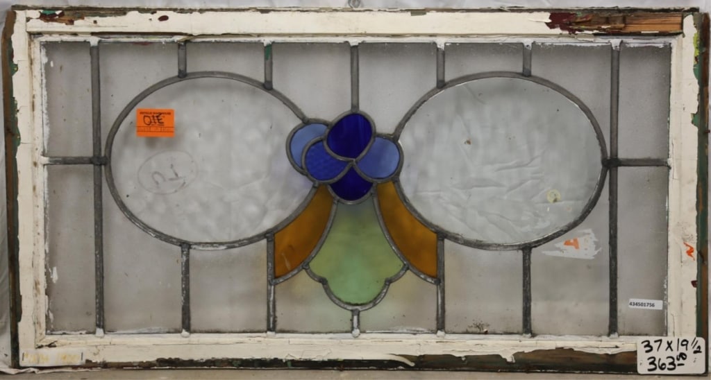 FRENCH ART NOUVEAU STAINED GLASS PANEL: French Art Nouveau stained glass panel with floral blue medallion and amber and green accents. Approximate dimensions: h. 19.5", w. 37" Disclaimer: This is an online court ordered bankruptcy sale. Par
