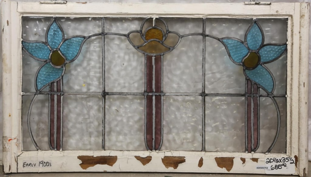 FRENCH ART NOUVEAU STAINED GLASS PANEL: French Art Nouveau stained glass panel with central floral medallion and two symmetrical blue flower details on the sides. Approximate dimensions: h. 20.5", w. 35.5" Disclaimer: This is an online cour