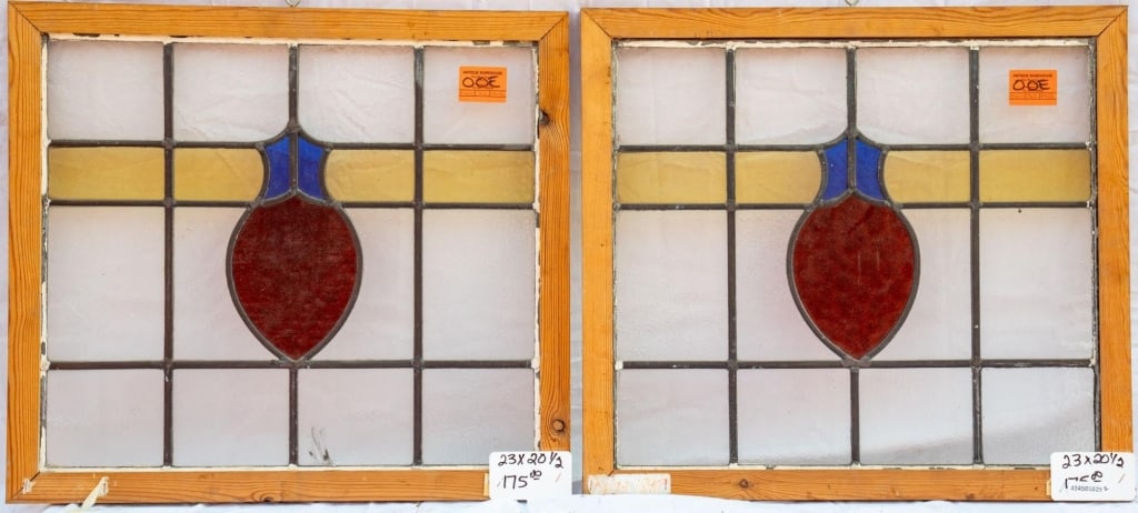 PAIR OF CONTINENTAL STAINED GLASS PANELS: Pair of Continental stained glass panels with shield-shaped stained glass medallions in purple, amber, and brown. Approximate dimensions: h. 20.5", w. 23" Disclaimer: This is an online court ordered b