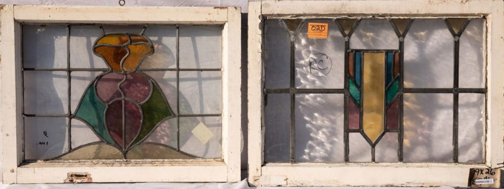 TWO CONTINENTAL STAINED GLASS PANELS: Two Continental stained glass panels, one with a floral medallion and the other with a geometric medallion. Approximate dimensions: h. 19", w. 26" Disclaimer: This is an online court ordered bankruptc