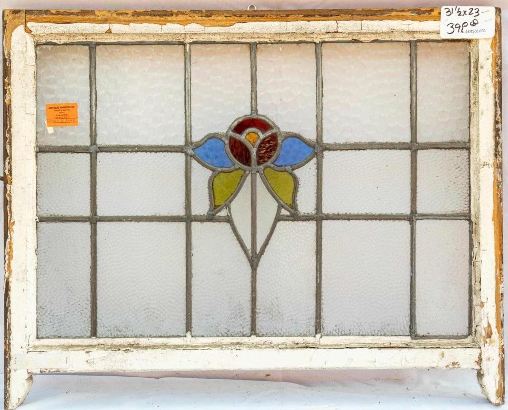 FRENCH ART NOUVEAU STAINED GLASS PANEL: French Art Nouveau stained glass panel with red, purple, and green floral details set within colorless textured leaded glass panels. Approximate dimensions: h. 23", w. 31.5" Disclaimer: This is an onl