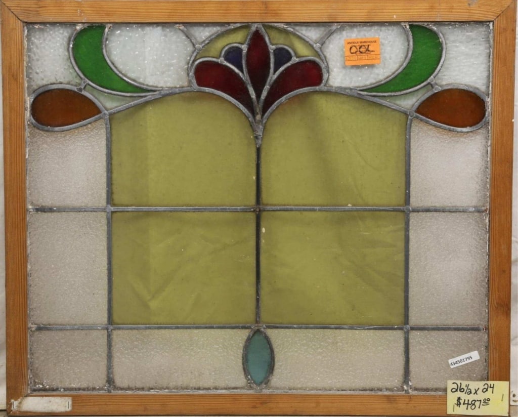 ANTIQUE CONTINENTAL STAINED GLASS PANEL: Antique Continental stained glass panel with floral medallion at the top center and leaf and amber glass accents to the sides. Approximate dimensions: h. 24", w. 26.5" Disclaimer: This is an online co