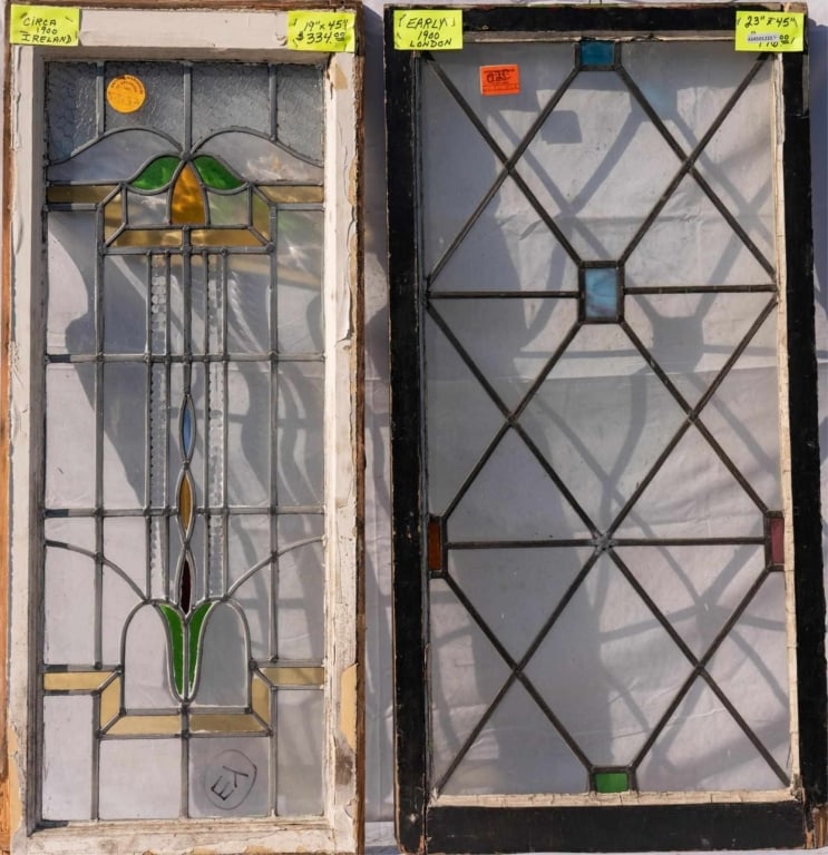 TWO CONTINENTAL STAINED GLASS PANELS: Two Continental stained glass panels with colorless leaded glass panels, one with wispy glass accents and the other with an abstract floral motif. Approximate dimensions: h. 45", w. 23" Disclaimer: Th