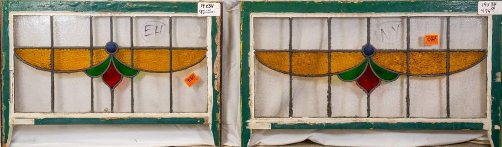 PAIR OF CONTINENTAL STAINED GLASS PANELS: Pair of Continental stained glass panels with an abstract floral motif in blue, green, and red, and textured amber glass accents. Approximate dimensions: h. 19", w. 34" Disclaimer: This is an online c