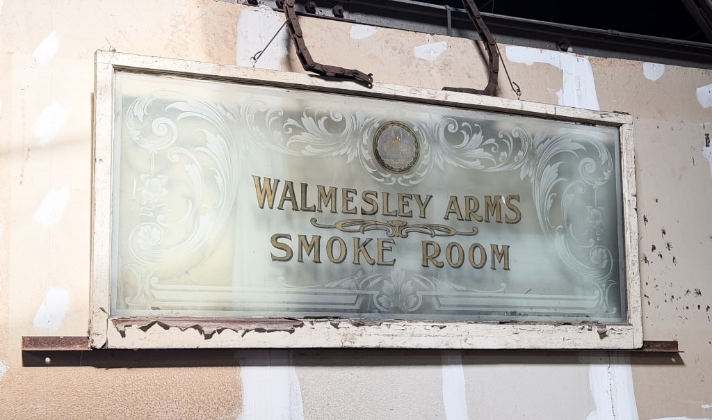 VINTAGE ETCHED GLASS WALMESLEY ARMS SMOKE ROOM SIG: Vintage "Walmesley Arms Smoke Rroom" etched glass sign. Approximate dimensions: h. 32", w. 72", d. 1.5" Disclaimer: Participating bidders must have a credit card on file with LiveAuctioneers in order