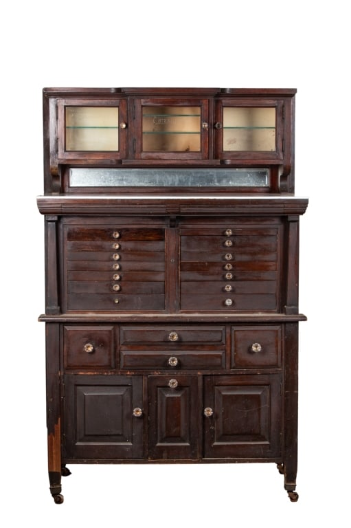 EARLY 20TH CENTURY MAHOGANY DENTAL CABINET: Early 20th century. Mahogany dental cabinet with beveled mirror backsplash, and castered legs. Approximate dimensions: h. 63.5", w. 40.5", d. 18" Disclaimer: Participating bidders must have a credit
