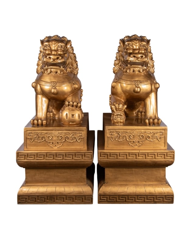 PAIR OF MONUMENTAL CHINESE GOLD BEIJING LIONS: Fiberglass; each depicted Beijing lion sitting atop a pedestal having geometric motifs. Approximate dimensions: h. 60", w. 27", d. 38.5" Disclaimer: Participating bidders must have a credit card on