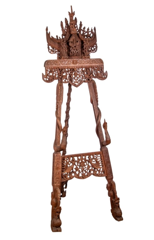 ORNATE BURMESE CARVED FLOOR EASEL: Ornate Burmese carved floor easel with figural serpents and intricately carved crest. Approximate dimensions: h. 70", w. 22.5", d. 20" Disclaimer: Participating bidders must have a credit card on file