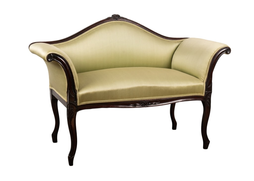 MAHOGANY CAMELBACK WINDOW BENCH: Mahogany camelback window bench with light green satin upholstery and floral carved accents. Approximate dimensions: h. 33", w. 46", d. 21.5" Disclaimer: Participating bidders must have a credit card