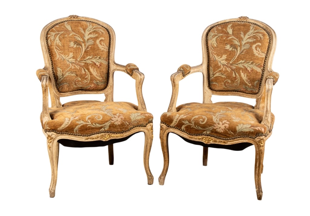 PAIR OF LOUIS XV STYLE FAUTEUIL ARMCHAIRS: Pair of Louis XV style fauteuil armchairs with carved frame, acanthus upholstery, brass nailhead trim. Approximate dimensions: h. 34", w. 23", d. 19" Disclaimer: Participating bidders must have a cred