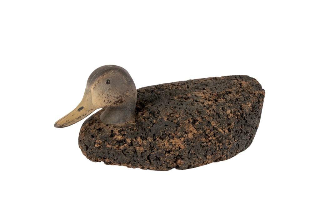 ANTIQUE CARVED CORK DUCK DECOY: Antique carved cork duck decoy. Approximate dimensions: h. 7", w. 16", d. 9" Disclaimer: Participating bidders must have a credit card on file with LiveAuctioneers in order for their bidding