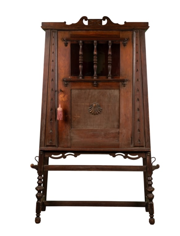 SPANISH COLONIAL STYLE BAR CABINET: Spanish Colonial Style bar cabinet (cellarette) with stretcher base and carved shell applique. Approximate dimensions: h. 66", w. 42", d. 16" Disclaimer: Participating bidders must have a credit card