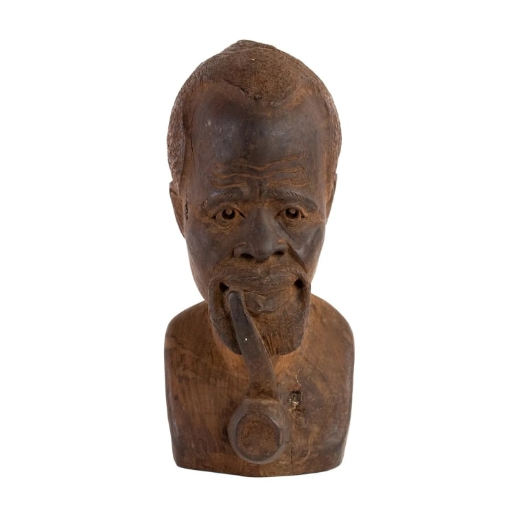 AFRICAN WOOD CARVED BUST SCULPTURE: African Kenyan hand carved wood bust depicting a man from the neck up smoking a pipe. Unmarked. Approximate dimensions: h. 13", w. 6", d. 6.5" Disclaimer: Participating bidders must have a credit