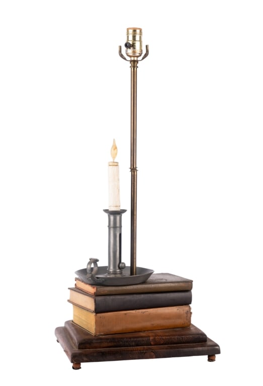 BOOK & CANDLESTICK TABLE LAMP: Book & candlestick table lamp. Approximate dimensions: h. 26", w. 11.5", d. 10.25" Disclaimer: Participating bidders must have a credit card on file with LiveAuctioneers in order for their bidding