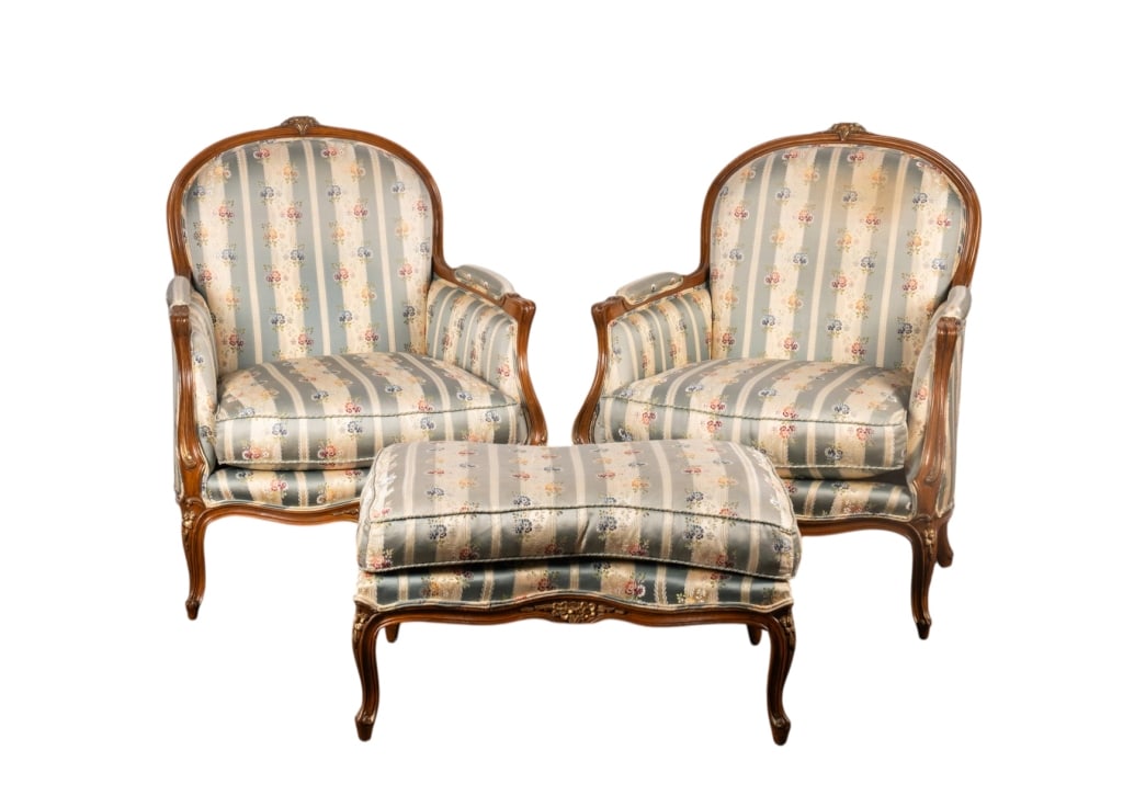 20TH C. LOUIS XV STYLE PAIR OF BERGERE CHAIRS & OT: American, 20th century. Louis XV style pair of bergeres and ottoman with floral upholstery, carved floral accents to legs and apron. Approximate dimensions: chair h. 39.5", w. 34", d. 34" Disclaimer: