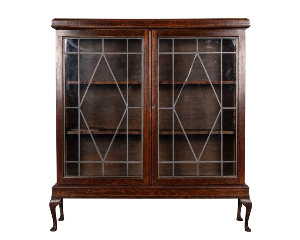 EARLY 20TH CENTURY WALNUT DISPLAY CABINET: Early 20th century walnut display cabinet with two lead glazed doors, two adjustable shelves, and cabriole legs. Approximate dimensions: h. 57", w. 52.5", d. 11.5" Disclaimer: Participating bidders