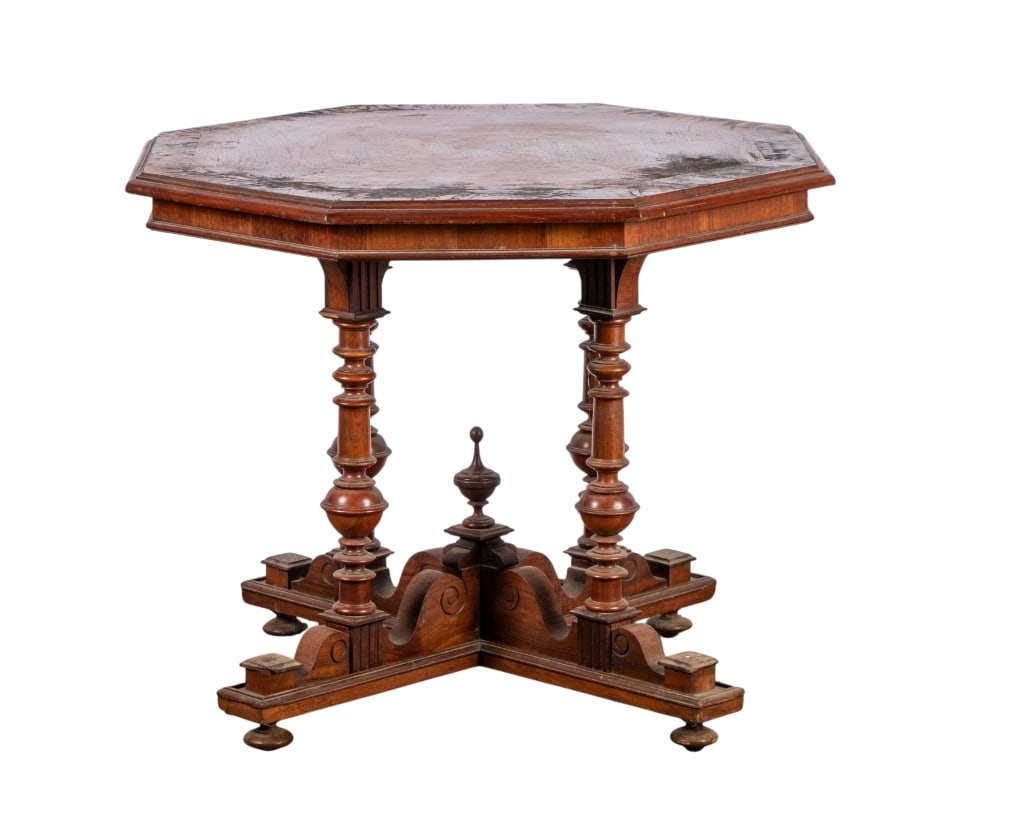 VICTORIAN GOTHIC REVIVAL OCTAGONAL TABLE: Victorian Gothic revival octagonal table with intricately carved base and turned legs. Approximate dimensions: h. 20", w. 35", d. 35" Disclaimer: Participating bidders must have a credit card on file