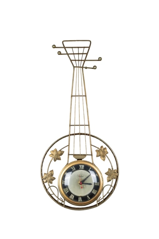 MID-CENTURY UNITED GOLDTONE WALL CLOCK: Mid-century United goldtone wall clock. Approximate dimensions: h. 23", w. 10", d. 2" Disclaimer: Participating bidders must have a credit card on file with LiveAuctioneers in order for their bidding