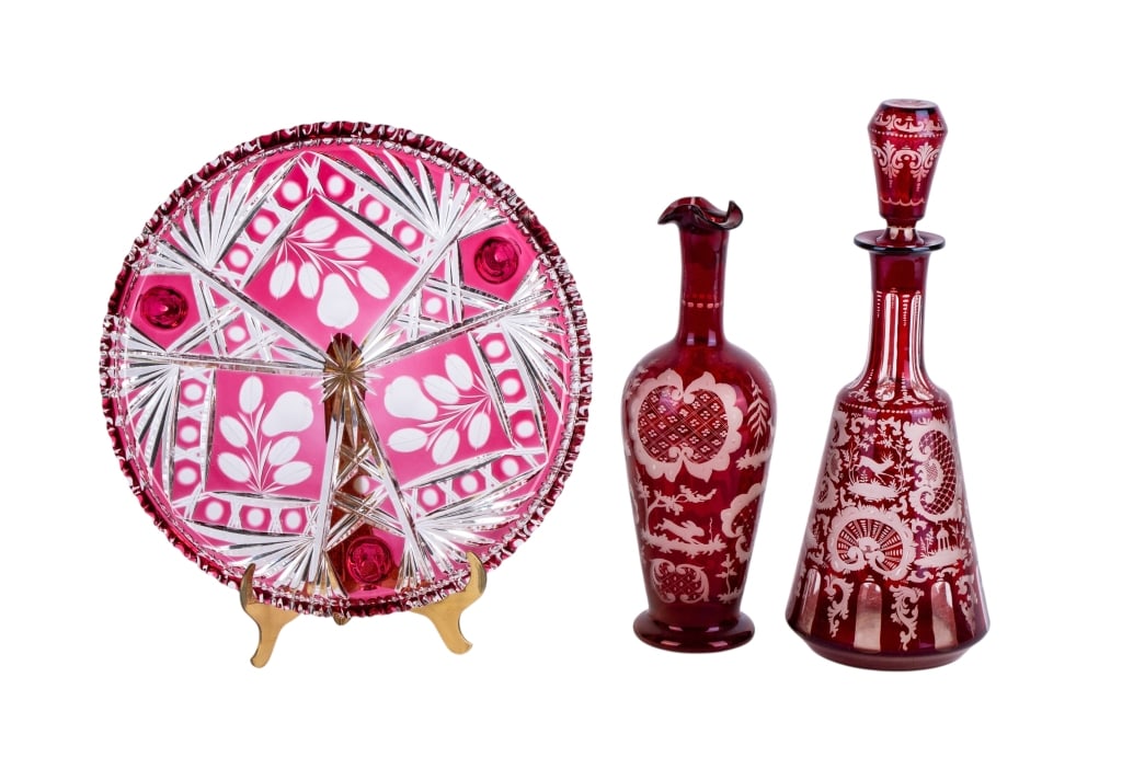 THREE 20TH CENTURY CRANBERRY GLASS ITEMS: Three 20th century cranberry glass items including platter, decanter and vase. Approximate dimensions: decanter h. 13.5", dia. 5" Disclaimer: Participating bidders must have a credit card on file