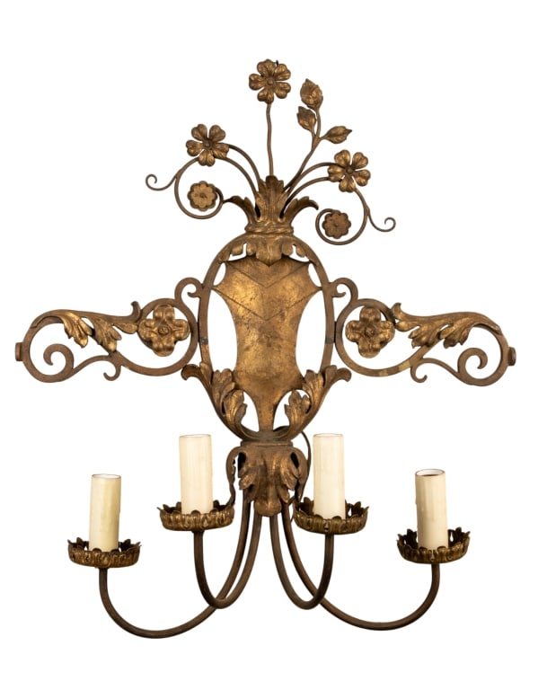 BRASS COAT OF ARMS FOUR ARM WALL SCONCE: Brass coat of arms four arm wall sconce with floral motif throughout. Approximate dimensions: h. 40", w. 19", d. 13" Disclaimer: Participating bidders must have a credit card on file with