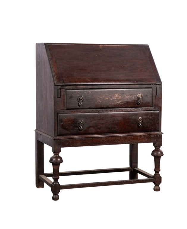 JACOBEAN STYLE SLANT FRONT DESK: Jacobean style slant front desk with stretcher base and brass teardrop pulls. Approximate dimensions: h. 38.5", w. 29.5", d. 16" Disclaimer: Participating bidders must have a credit card on file with