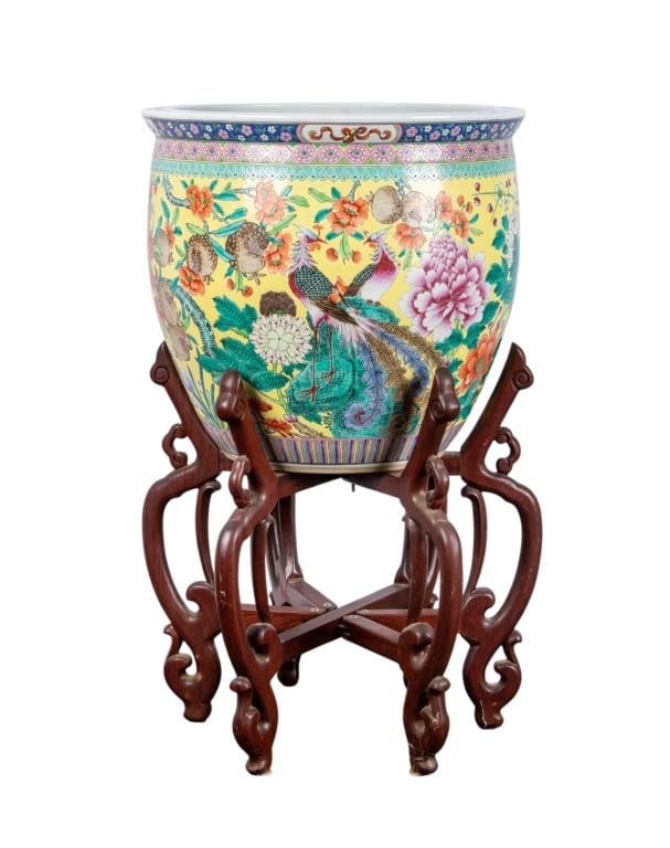 20TH C FAMILLE ROSE FISH BOWL: 20th century Famille Rose fish bowl on wooden stand with scrolled legs. Approximate dimensions: bowl h. 20", dia. 21" Disclaimer: Participating bidders must have a credit card on file with