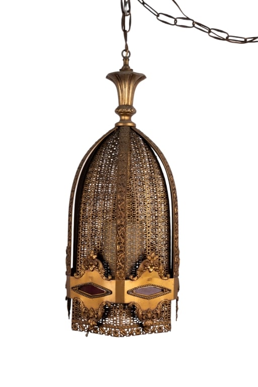 ART DECO SWAG LIGHT WITH RED GLASS ACCENTS: Art Deco swag light with red glass accents and intricate brass filigree surface. Approximate dimensions: h. 25.5", dia. 11" Disclaimer: Participating bidders must have a credit card on file with