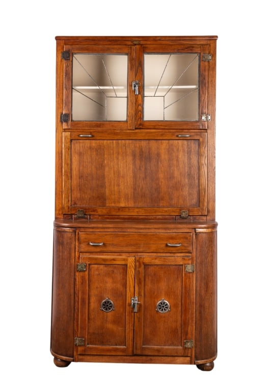 ARTS & CRAFTS NUERA CUPBOARD CABINET: Arts & Crafts Nuera cupboard cabinet with leaded glass doors and drop front. Approximate dimensions: h. 72", w. 36", d. 19" Disclaimer: Participating bidders must have a credit card on file with