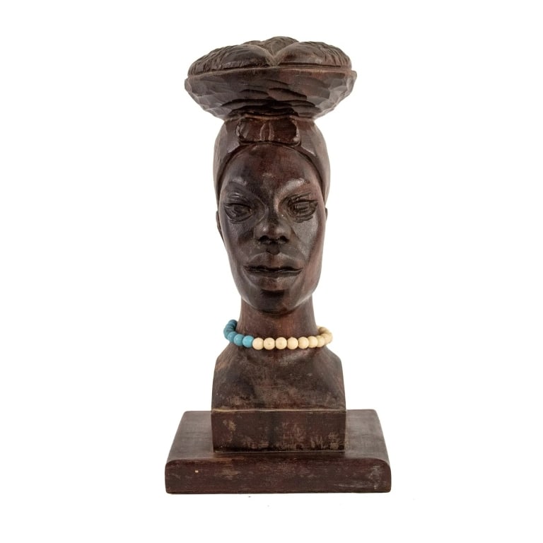 AFRICAN HAND CARVED WOOD BUST OF A WOMAN: African hand-carved wood bust depicting the face of a tribal woman wearing a headdress and a beaded necklace. Approximate dimensions: h. 9.25", w. 4.5", h. 3.75" Disclaimer: Participating bidders