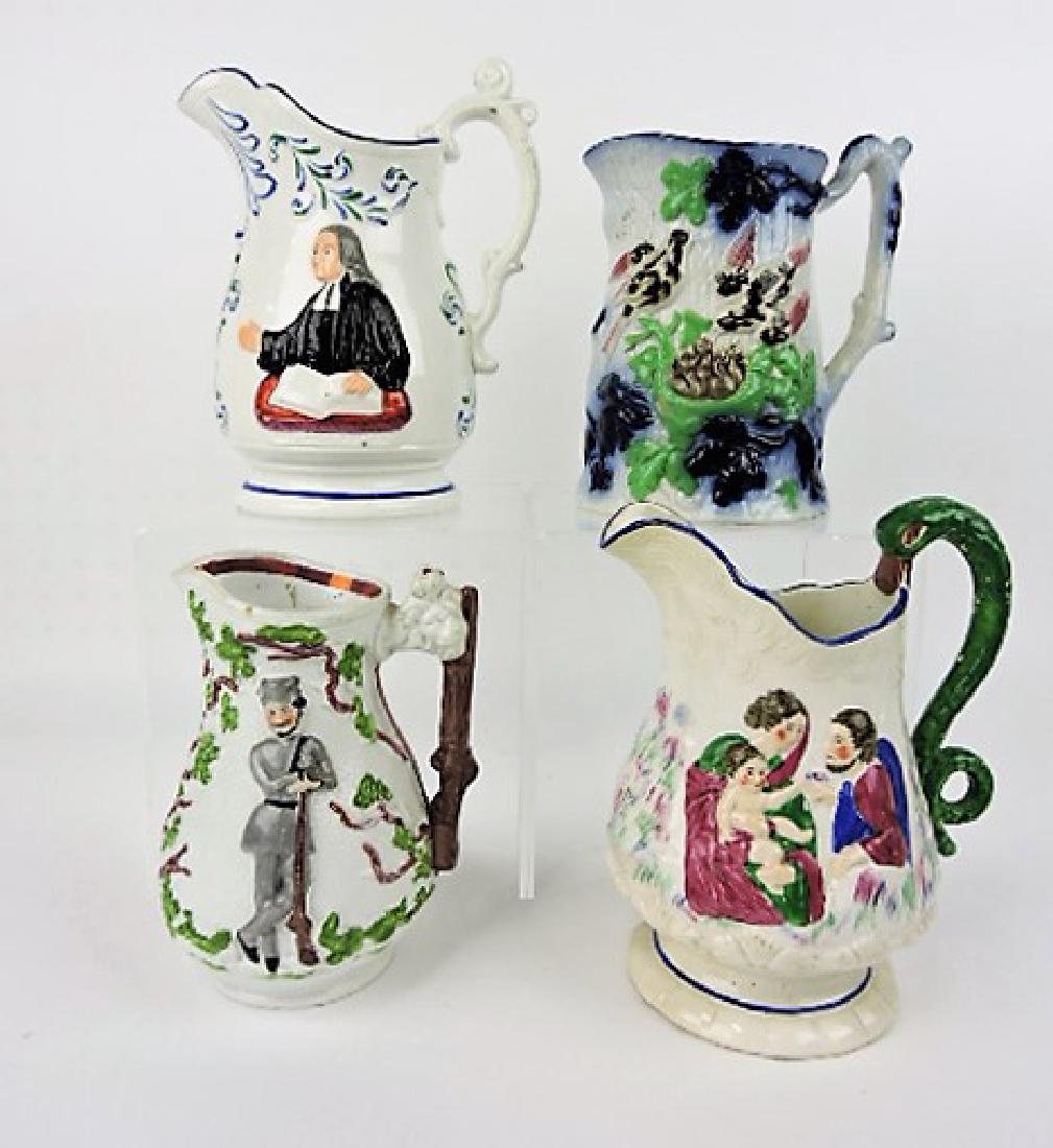 English jug lot of 4, v.c.: . small nick to rim of John Wesley pitcher, spout nick to soldier pitcher, spout nick to pitcher with snake handle