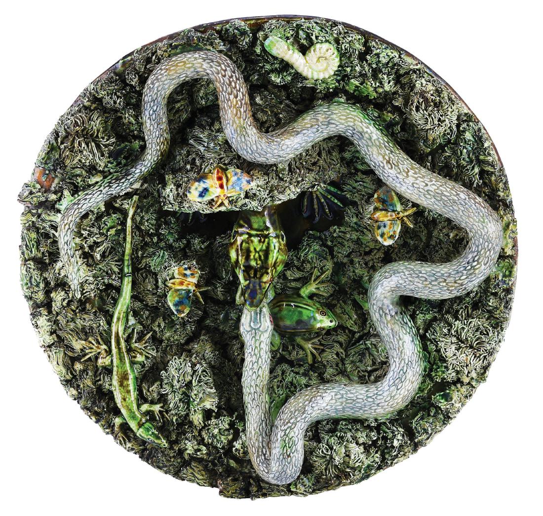 Jose Cuhna Majolica Palissy Plaque c.1875,: circular, green grass with moths, shell and small lizard, a larger lizard emerging from a grotto biting the head of a large snake, 11". Curated and catalogued by Nicolaus Boston