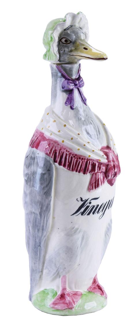 German Majolica Mother Goose Vinegar Bottle c.1910: modeled as a goose dressed in a shawl and bonnet, "Vinegar"™ painted across the body, the head forming the bottle, 11". Curated and catalogued by Nicolaus Boston